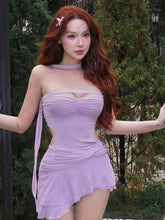 Person wearing a light purple dress with a scenic background